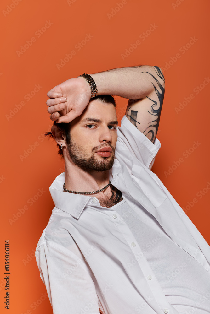 A stylishly dressed man displays intricate tattoos on his arm. A stylishly dressed man displays intricate tattoos on his arm.