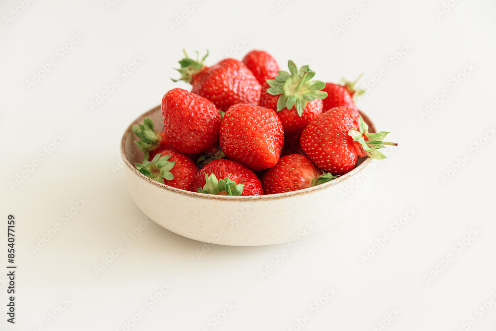 Fresh strawberries into bowls on white table. Summer food concept. Soft focus Fresh strawberries into bowls on white table. Summer food concept. Soft focus