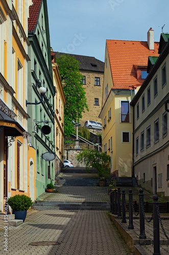 Scenic view of the historical street of medieval Loket with colorful buildings and cobblestone road by summer day. Bohemia, Sokolov, Karlovarsky Region, Czech Republic. UNESCO World Heritage Site