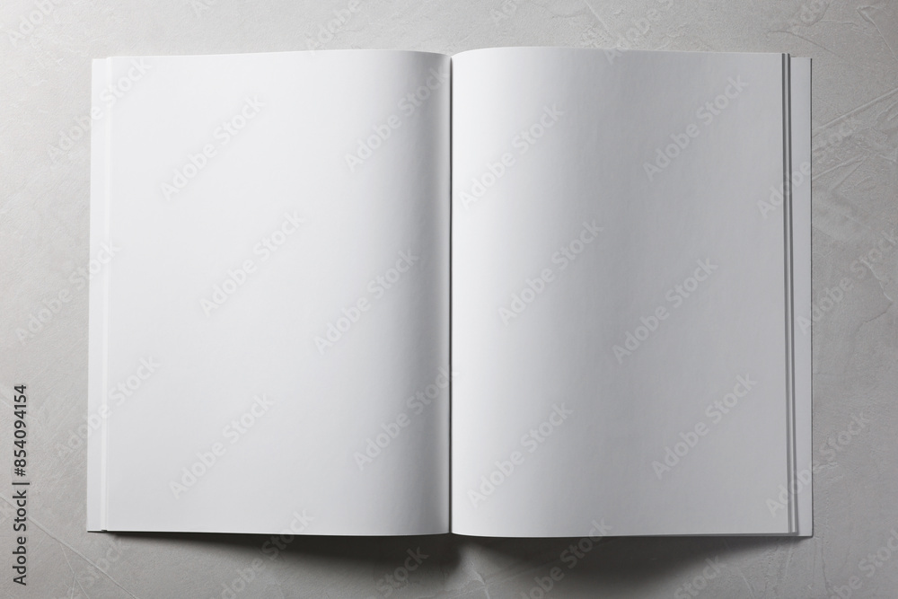 Open notebook with blank pages on grey textured background, top view. Mockup for design