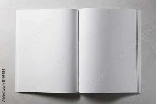 Open notebook with blank pages on grey textured background, top view. Mockup for design