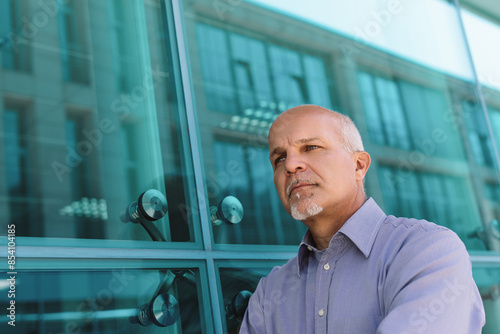 Pensive businessman contemplating future in front of modern offi