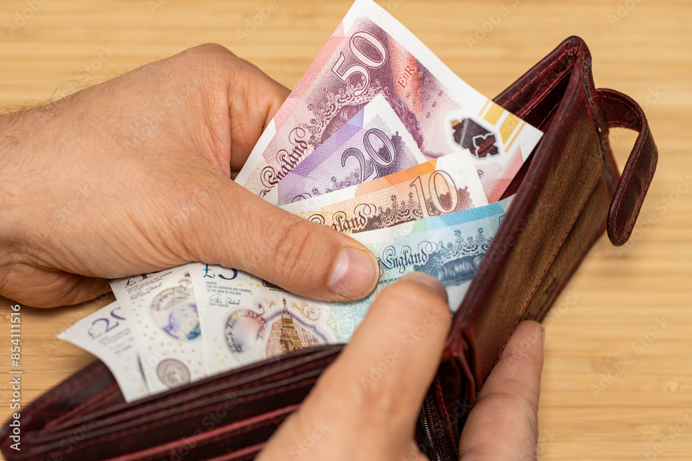 Hand takes out money from the wallet, British Pound banknotes, concept, rising prices, value of English currency