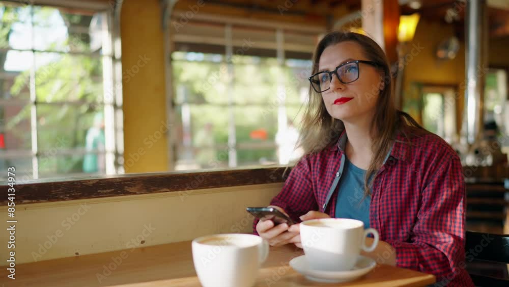 Woman is using smartphone and drinking coffee in the cafe Woman is using smartphone and drinking coffee in the cafe