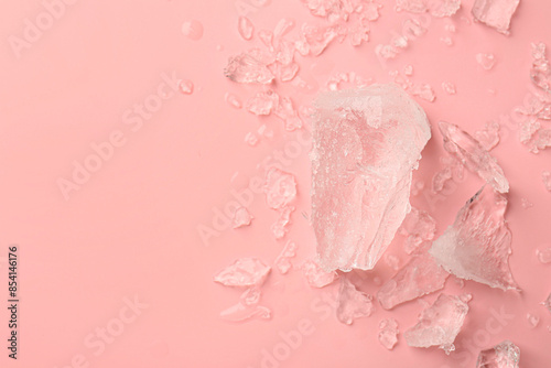 Pieces of crushed ice on pink background, top view. Space for text © New Africa