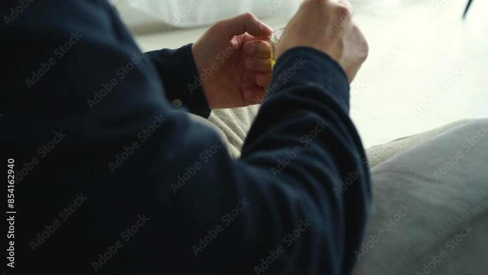 A man sits on the sofa and holds tea in his hands.
Hot tea in a transparent cup.
Man holding a drink in his hands A man sits on the sofa and holds tea in his hands.
Hot tea in a transparent cup.
Man holding a drink in his hands