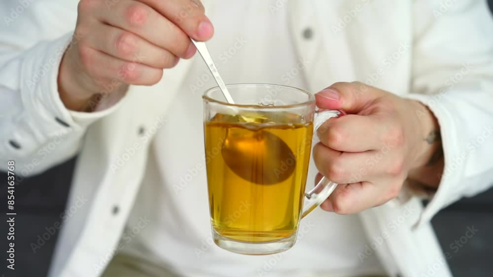Green tea in a transparent cup.
A man stirs tea with a teaspoon.
Hot tea with takane Green tea in a transparent cup.
A man stirs tea with a teaspoon.
Hot tea with takane