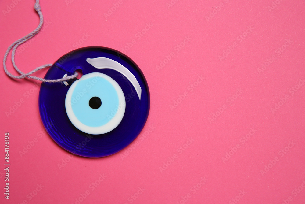 Evil eye amulet on pink background, top view. Space for text Evil eye amulet on pink background, top view. Space for text