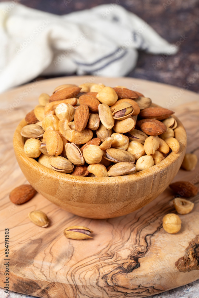 Mixed nuts on wooden background. Nuts in a bowl. Close up Mixed nuts on wooden background. Nuts in a bowl. Close up