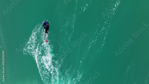 Aerial slow-motion shot of a man swimming in the sea of Playa Valcovo in Arteixo, Spain. photo