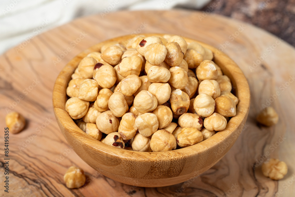 Hazelnuts on wood background. Roasted hazelnuts in a bowl. Close up Hazelnuts on wood background. Roasted hazelnuts in a bowl. Close up