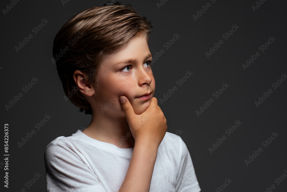 Portrait of thinking boy on dark background Portrait of thinking boy on dark background