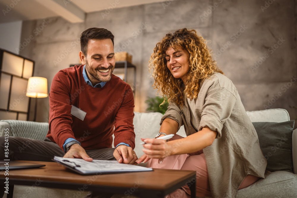 Woman sign insurance policy, contract to man financial adviser at home Woman sign insurance policy, contract to man financial adviser at home
