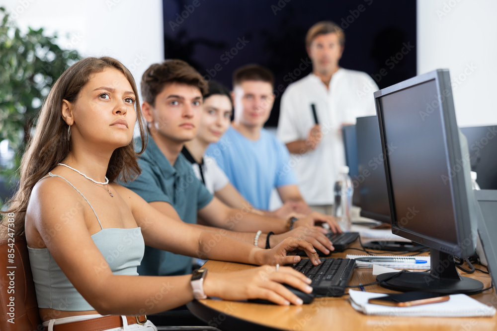 Fototapeta premium In classroom, atmosphere of intense focus prevails as teacher engages students in thought-provoking discussions.