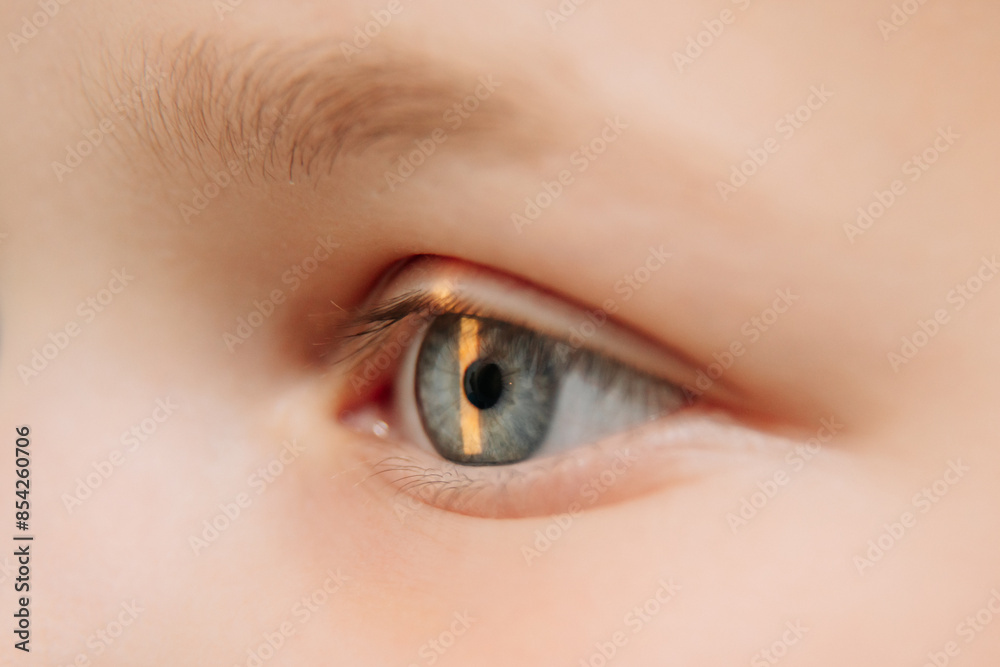 Fototapeta premium Examination of the child using a slit lamp. Microscope and focused light source. A device for high-precision examination of the eye to determine the condition of the lens.