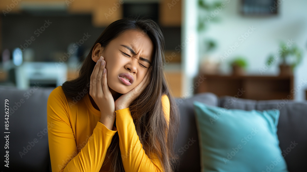 Woman experiencing severe toothache at home, displaying pain and discomfort Woman experiencing severe toothache at home, displaying pain and discomfort