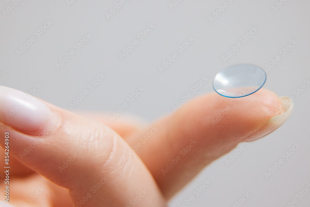Contact lenses for vision correction. A woman holds a contact lens on her finger, close-up. Contact lenses for vision correction. A woman holds a contact lens on her finger, close-up.