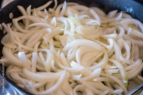 the preparation and cooking process of onions, highlighting various techniques and states, such as sautéed, roasted, caramelized, and the use of kitchen tools like skillets and frypans photo