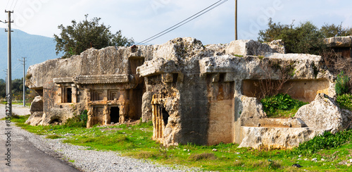 View of rock burial chambers ruins in antique Lycian settlement of Araxa, Oren village, Turkey photo