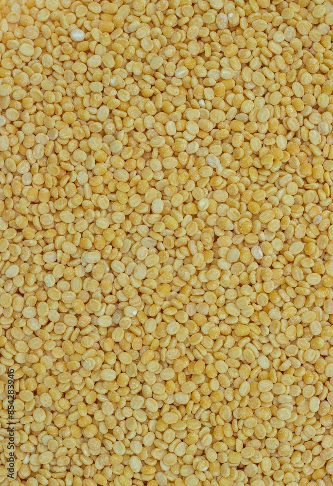 Top View of Yellow Moong Dal or Green Gram Beans Background with Copy Space in Vertical Orientation
