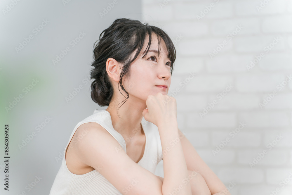 頬杖をついて考える・悩む女性（美容・ダイエット）
