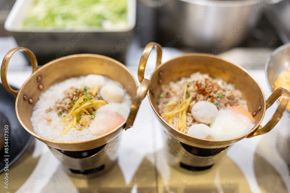 Pork porridge with eggs in a bowl is delicious for breakfast at the reception in a famous chef's kitchen in a 5-star hotel. Prepared with care and with vegetables such as scallions, ginger, and pepper Pork porridge with eggs in a bowl is delicious for breakfast at the reception in a famous chef's kitchen in a 5-star hotel. Prepared with care and with vegetables such as scallions, ginger, and pepper