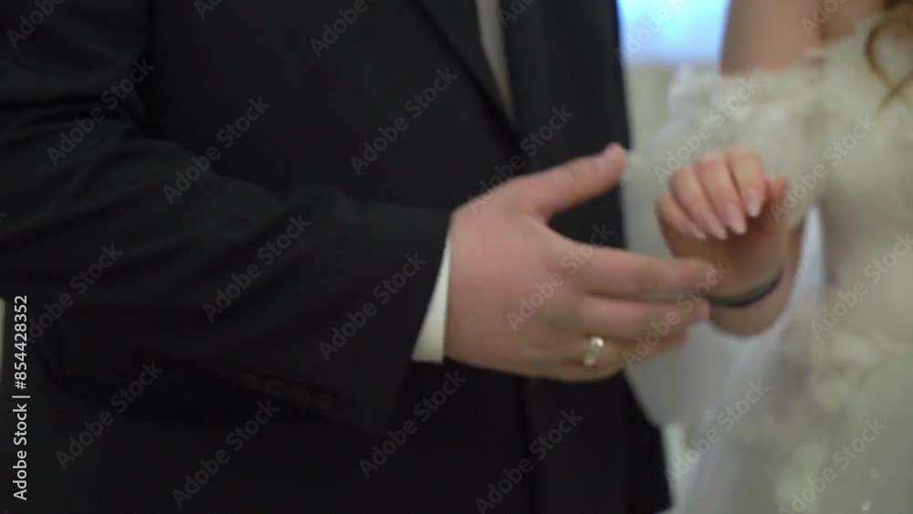 During a wedding ceremony, the groom affectionately places a wedding ring on the brides finger in a closeup shot, symbolizing their love and commitment to each other in this intimate moment During a wedding ceremony, the groom affectionately places a wedding ring on the brides finger in a closeup shot, symbolizing their love and commitment to each other in this intimate moment