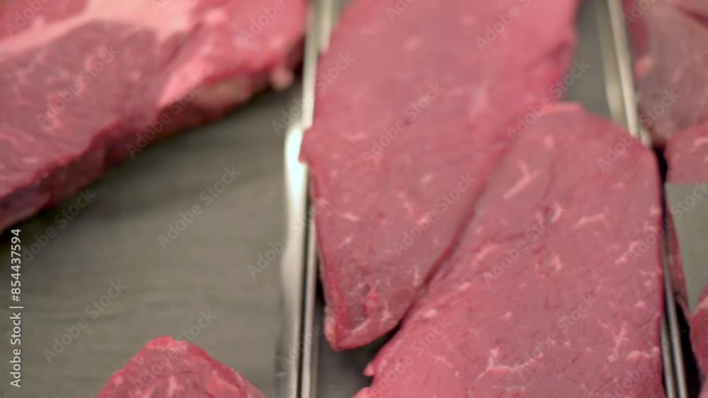 Close-up of raw beef steaks neatly arranged in a grocery store meat counter. The image showcases the freshness and quality of the beef, ready for customers to purchase and cook. 4k footage Close-up of raw beef steaks neatly arranged in a grocery store meat counter. The image showcases the freshness and quality of the beef, ready for customers to purchase and cook. 4k footage