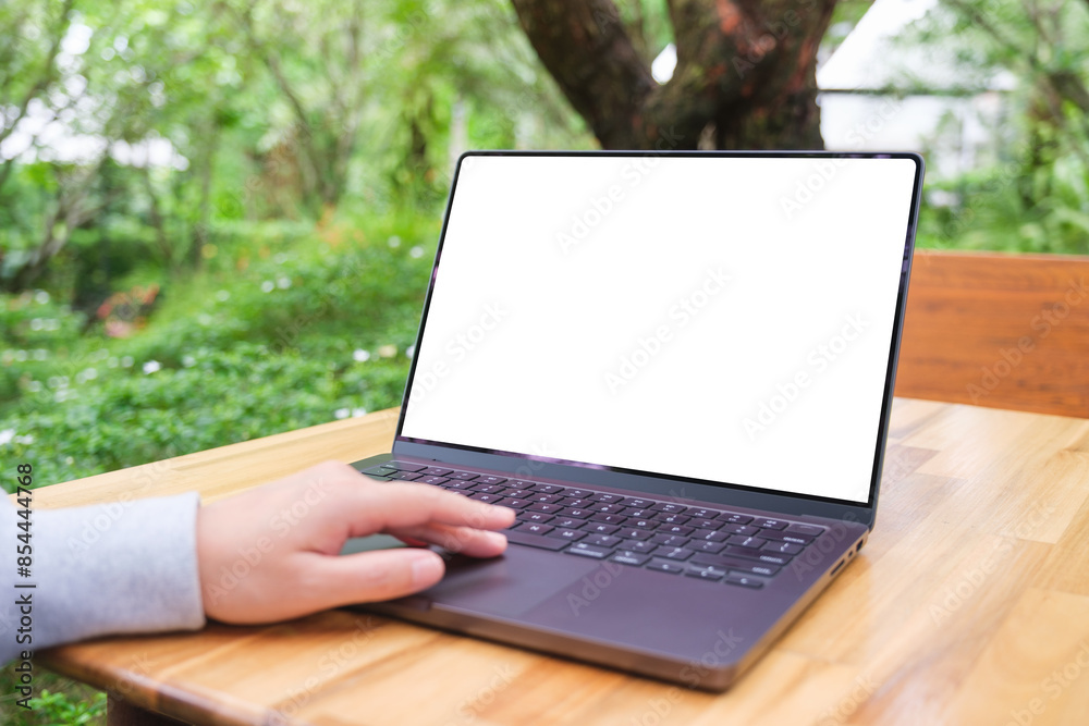 © Farknot Architect - Mockup image of a woman using and touching on laptop computer touchpad with blank white desktop screen in the outdoors