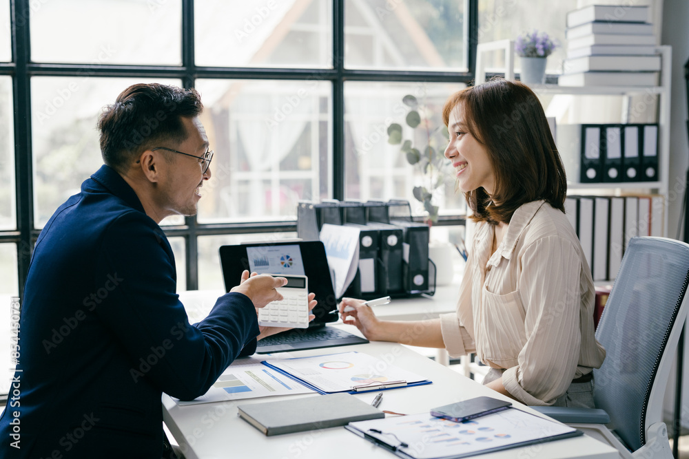Business Meeting in Modern Office with Two Professionals Discussing Documents and Charts by Large Window Business Meeting in Modern Office with Two Professionals Discussing Documents and Charts by Large Window