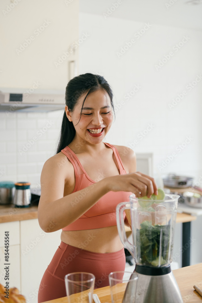 Woman in Sportswear Preparing a Healthy Smoothie in a Modern Kitchen with Fresh Ingredients Woman in Sportswear Preparing a Healthy Smoothie in a Modern Kitchen with Fresh Ingredients