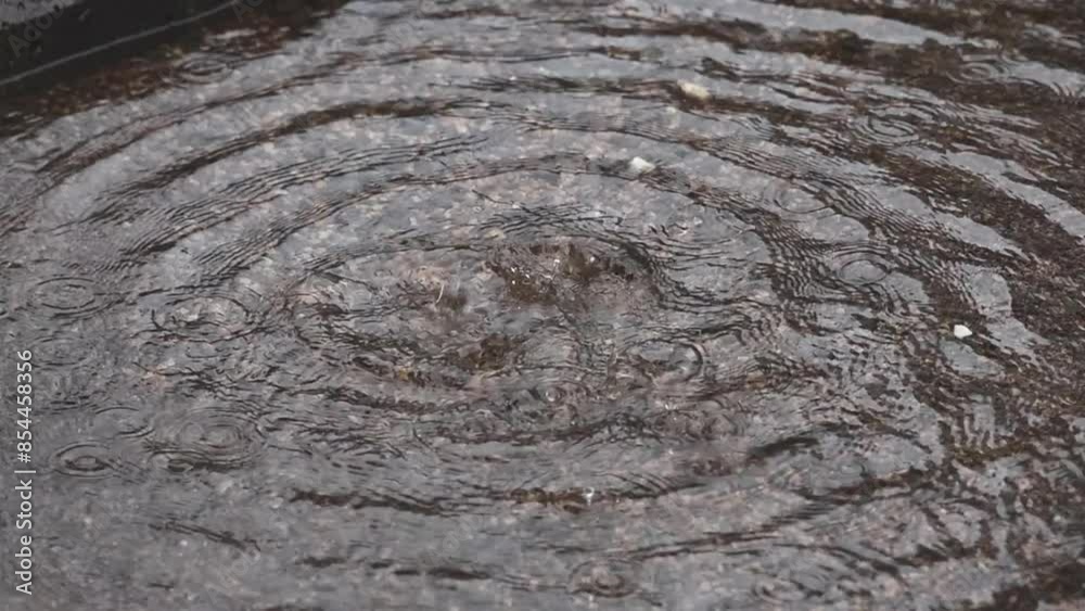 Raindrops falling on the water surface of the fountain. Rainy day, Slow motion Raindrops falling on the water surface of the fountain. Rainy day, Slow motion