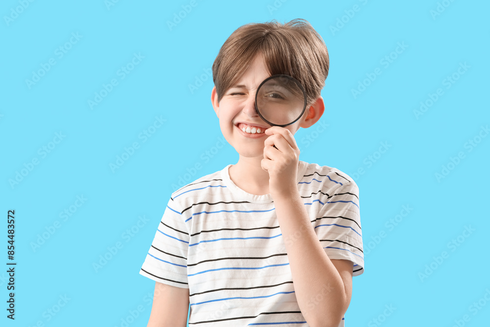 Little boy with magnifier on blue background Little boy with magnifier on blue background