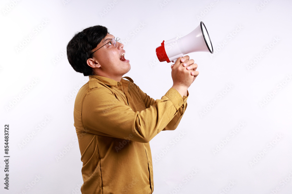 Young Indonesian civil servant hold scream shout in megaphone announces discounts sale Hurry up isolated on white background studio portrait. Young Indonesian civil servant hold scream shout in megaphone announces discounts sale Hurry up isolated on white background studio portrait.