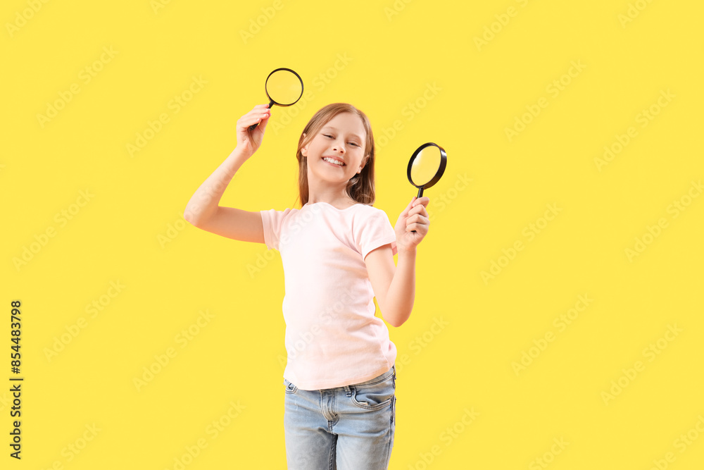 Little girl with magnifiers on yellow background Little girl with magnifiers on yellow background