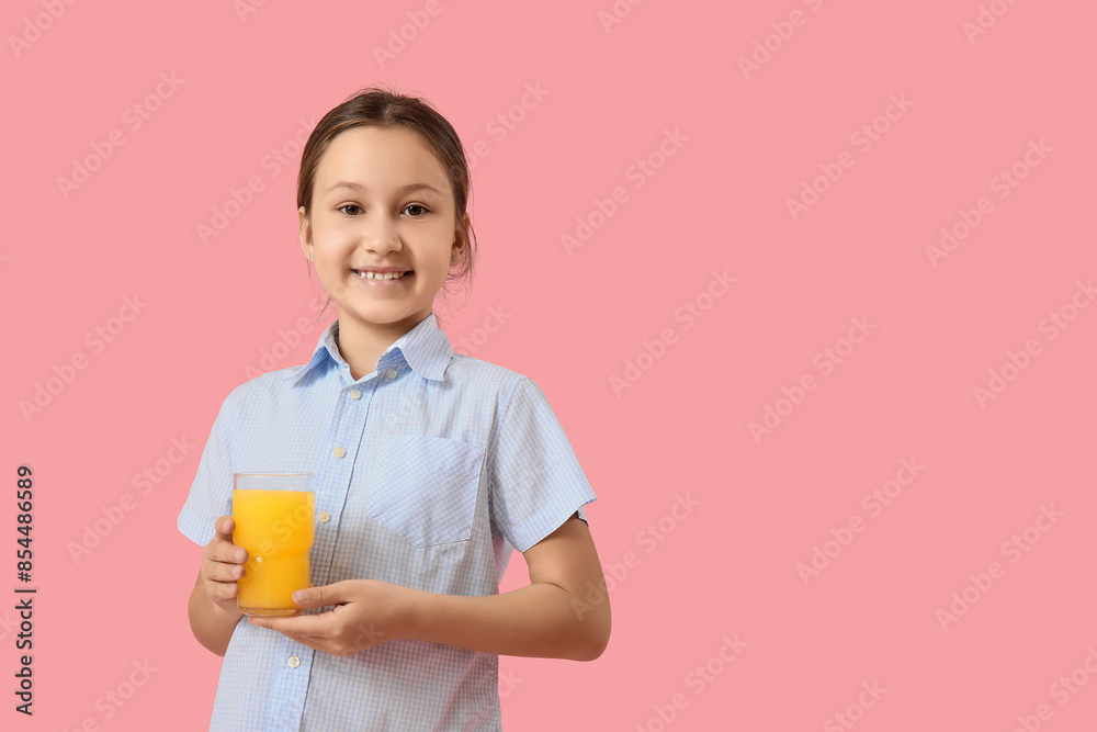 Cute little girl with glass of orange juice on pink background Cute little girl with glass of orange juice on pink background