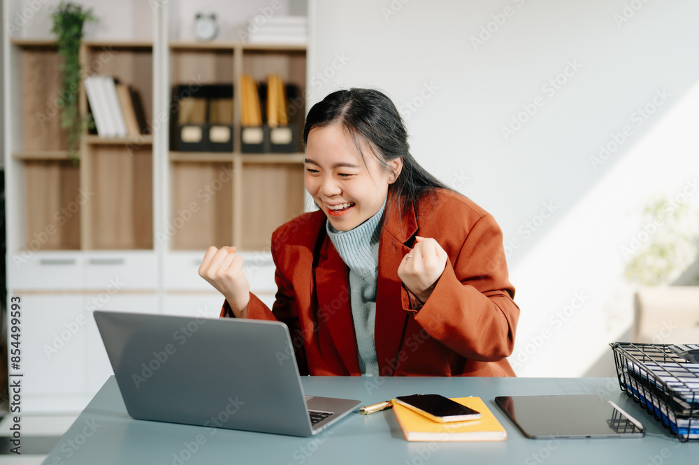 Asian woman using laptop and tablet while sitting at her working place. Asian woman using laptop and tablet while sitting at her working place.