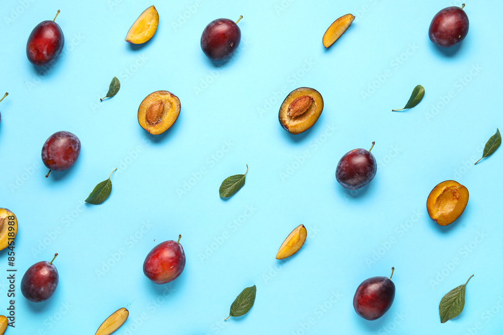 Fresh ripe plums and leaves on blue background Fresh ripe plums and leaves on blue background