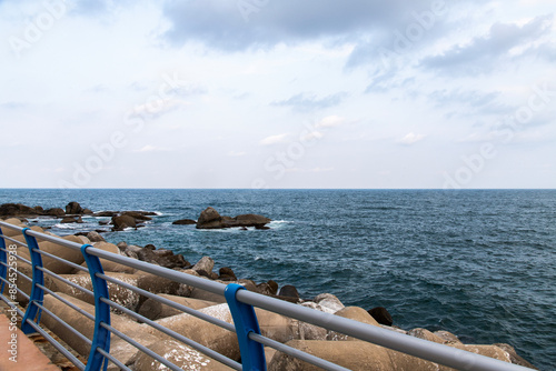 View of the fence on the seawall and cloudy sea photo