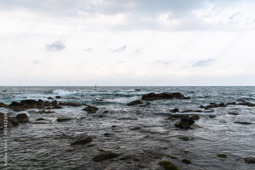 cloudy seascape with rocky beach cloudy seascape with rocky beach