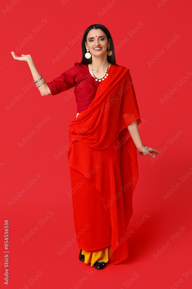 Beautiful young Indian woman in sari on red background. Divaly celebration Beautiful young Indian woman in sari on red background. Divaly celebration