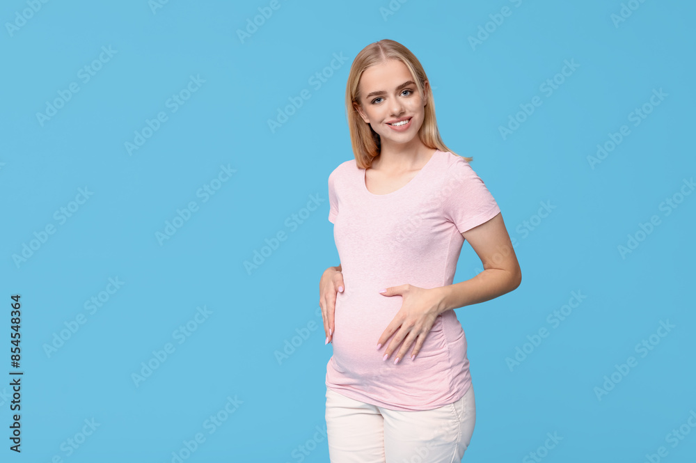Beautiful happy young pregnant woman on blue background Beautiful happy young pregnant woman on blue background