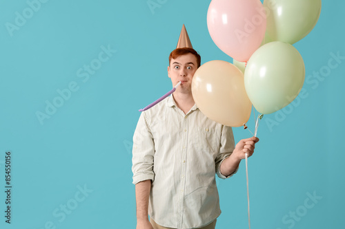 Young man with party whistl...