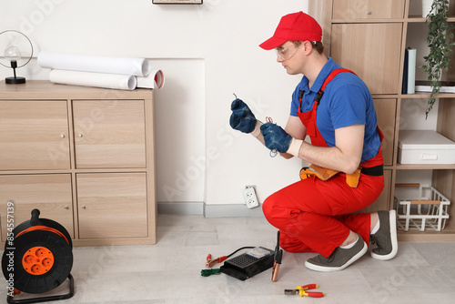 Male electrician repairing ...