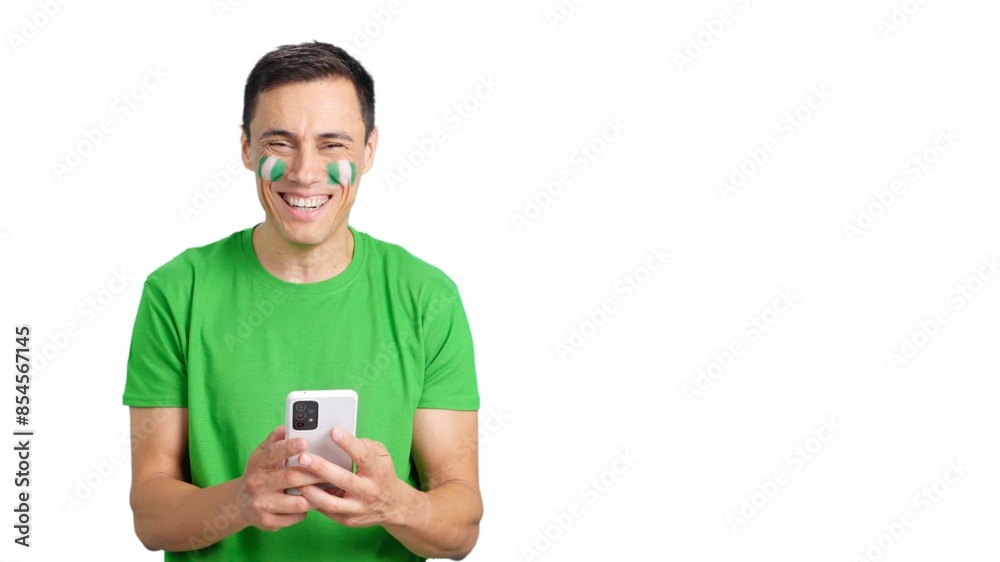 Nigeria supporter looking at his mobile smiling and showing it. Nigeria supporter looking at his mobile smiling and showing it.