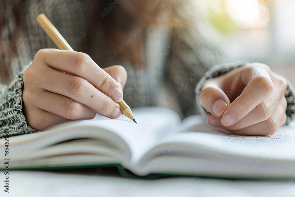 Close-up of hands taking notes in a notebook detailed Close-up of hands taking notes in a notebook detailed