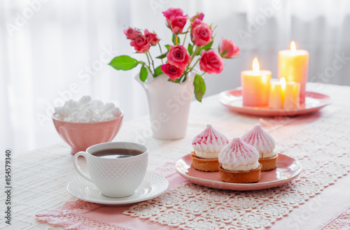 cup of coffee with dessert and roses on table
