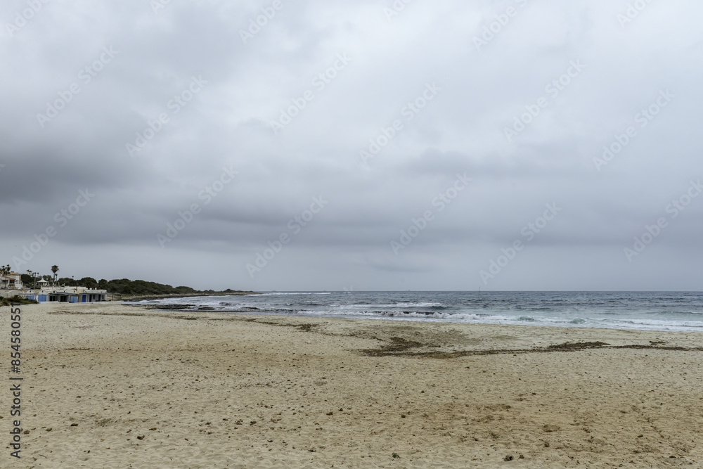 Distant Sailboat on Overcast Day at Punta Prima Beach Distant Sailboat on Overcast Day at Punta Prima Beach