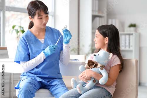 Little Asian girl with toy ...