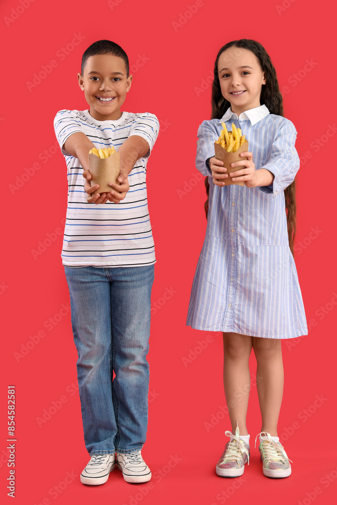 Happy cute little children with french fries on red background Happy cute little children with french fries on red background